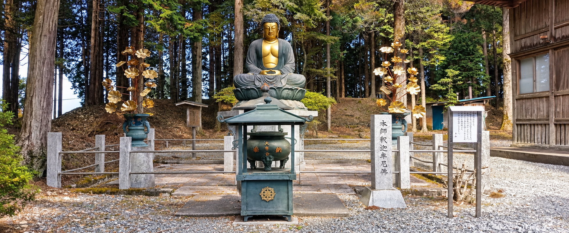 Statua lignea del Buddha accanto ai loti in ottone
